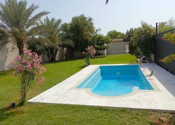 استراحة بمسبح خارجي ومسطح اخضر