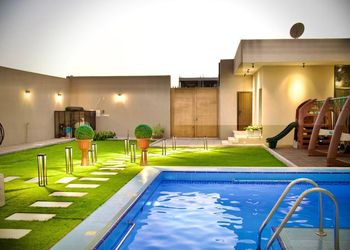 شاليه بمسبح خارجي ومسطح اخضر.