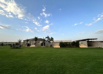 مزرعة بمسطحات خضراء وجلسة خارجية
