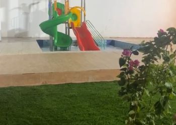 كوخ بألعاب مائية ومسطح اخضر