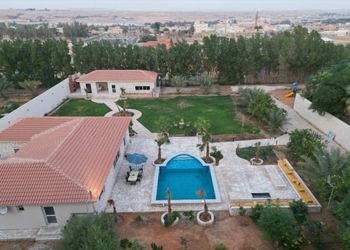 مزرعة بمسطحات خضراء وجلسة خارجية