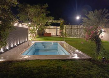 استراحة بمسبح خارجي ومسطح اخضر