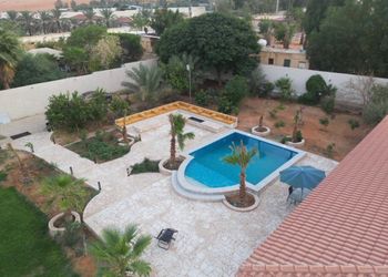 مزرعة بمسطحات خضراء وجلسة خارجية