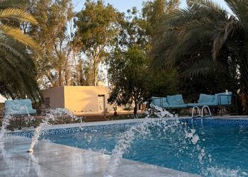 مزرعة بمسطحات خضراء وجلسة خارجية